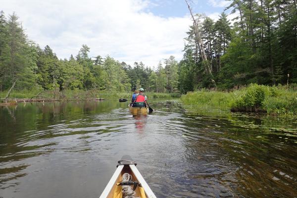 Front of a canoe looking ahead paddling from Fish Creek to Upper Saranac Lake