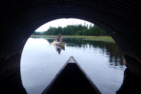 canoeing through culvert with paddler in the distance